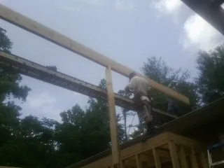 Carpenter setting a ridge beam over a new addition frame — Ice Dam Removal by Roofing Brothers in Marysville